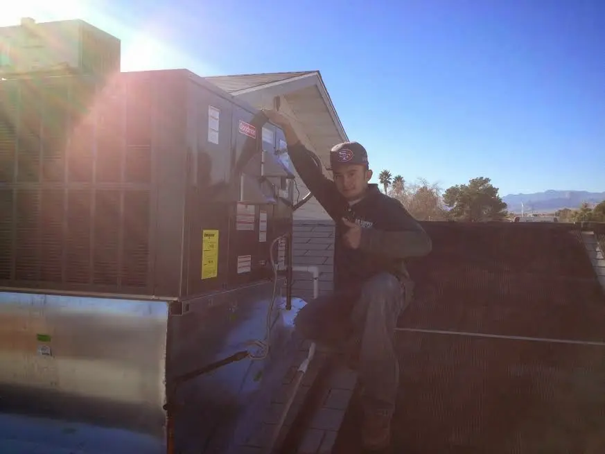 HVAC technician performing AC Tune-Up on a rooftop unit in Oviedo